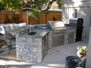 Outdoor kitchen with a gas grill and smoker