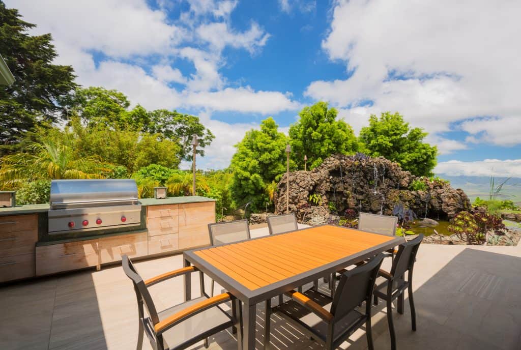 Backyard patio with BBQ grill and dining table on deck