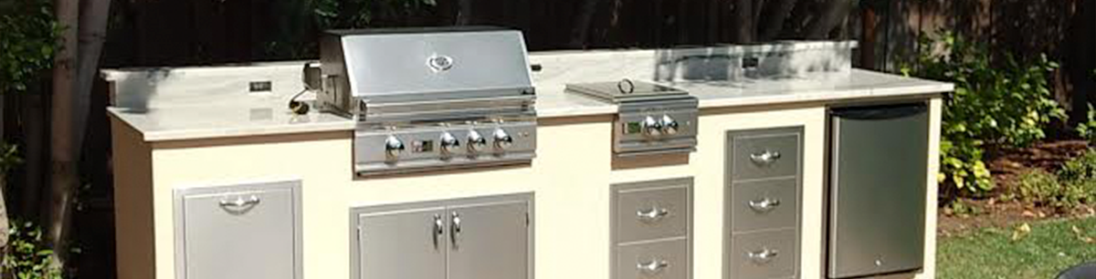 Small outdoor kitchen with gas grill, mini fridge and side burner