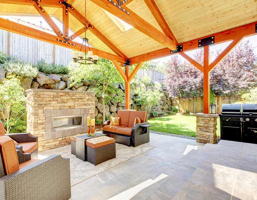 beautiful wood-beamed covered patio with grill and fireplace